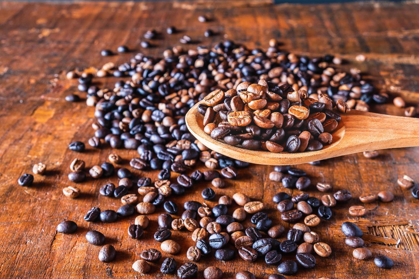 Grains de café torréfiés sur une cuillère en bois photo