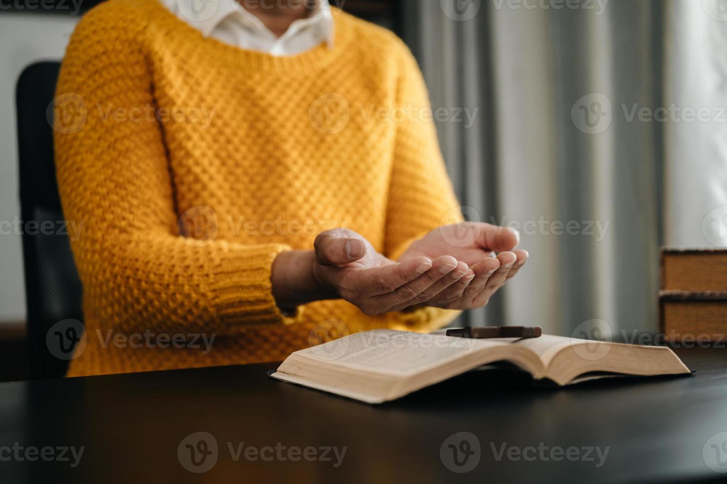 les mains ensemble dans la prière à dieu avec la bible dans le concept chrétien et la religion, la femme prie dans la bible sur la table en bois photo
