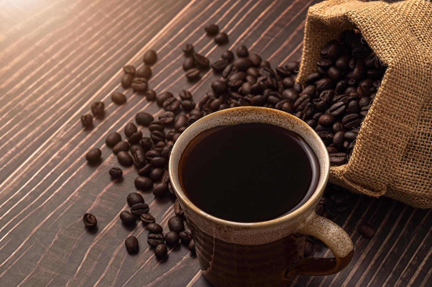 Une tasse de café et des grains de café sur une table en bois, concept de café d'amour photo