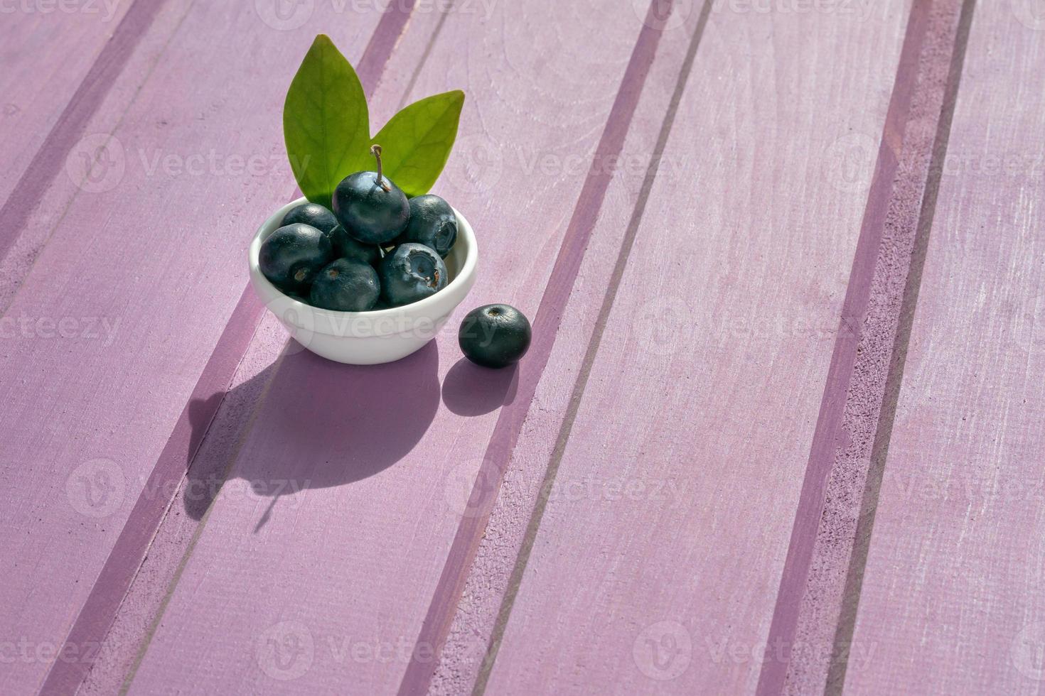 sur une violet en bois Contexte est une assiette avec Frais myrtilles photo