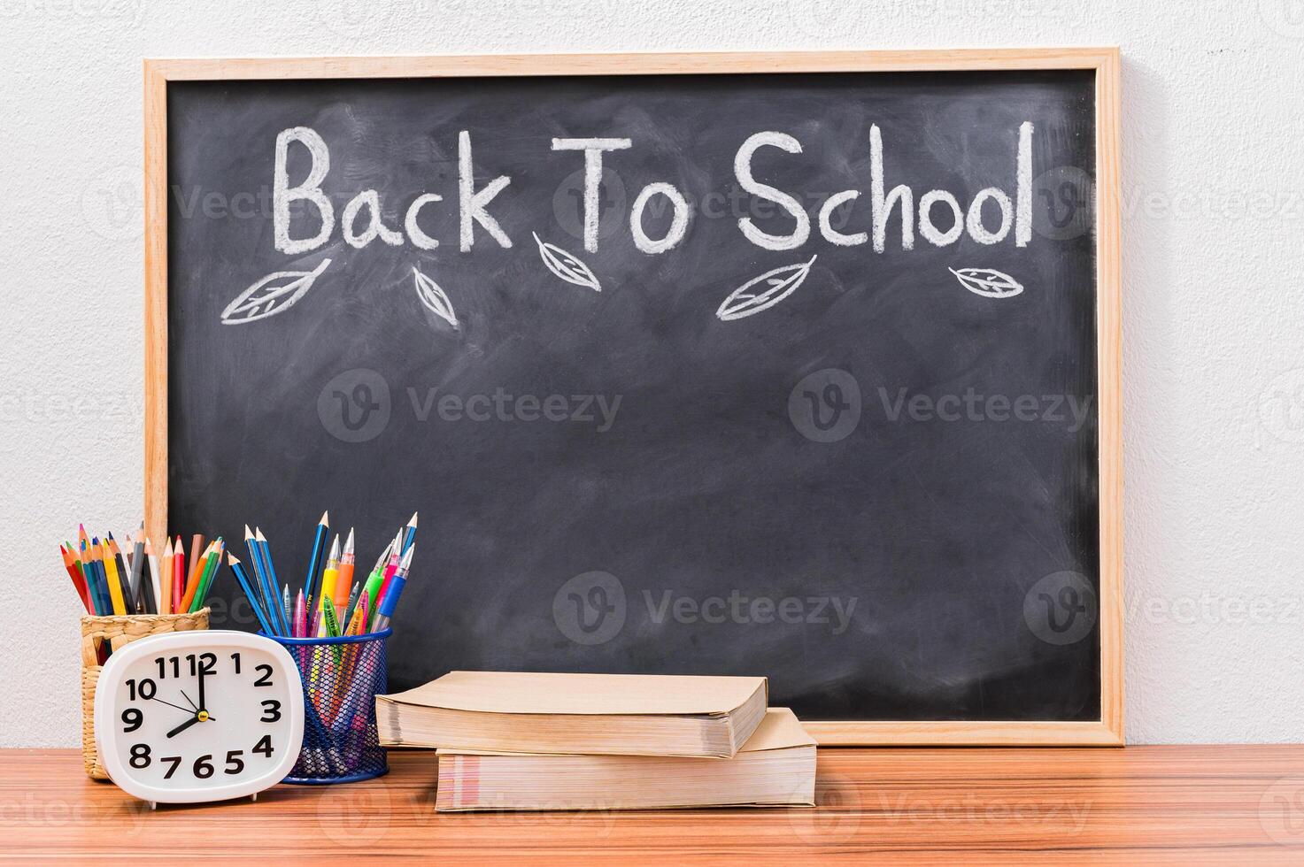 Un tableau avec des fournitures scolaires sur une table en bois, retour à l'école et le concept de l'éducation photo