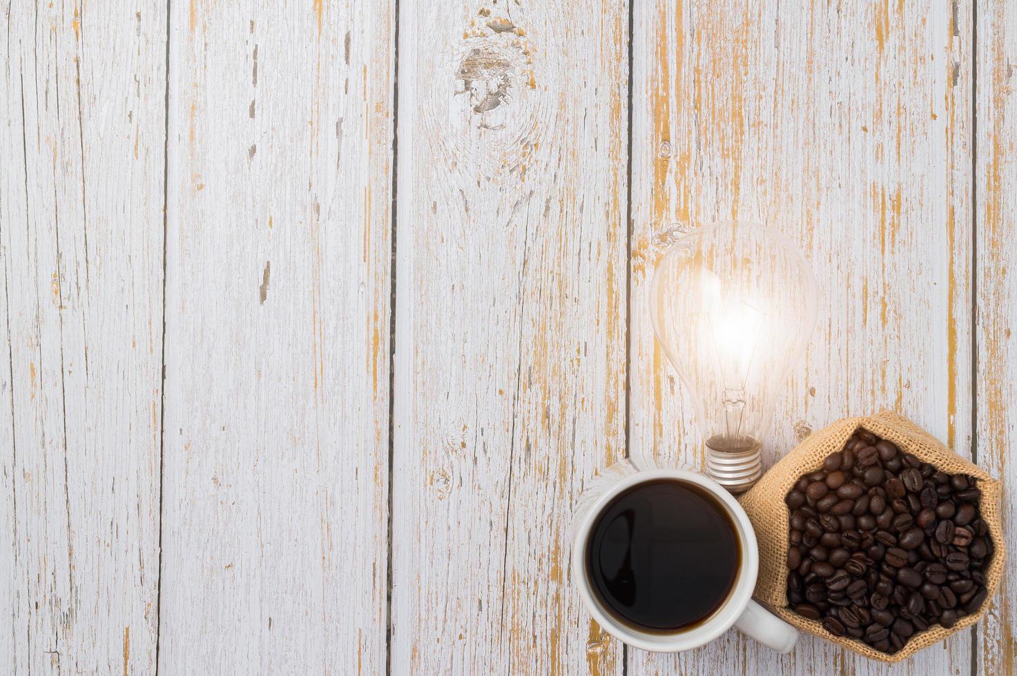 tasse à café et une ampoule émettant de l'énergie sur une table en bois photo