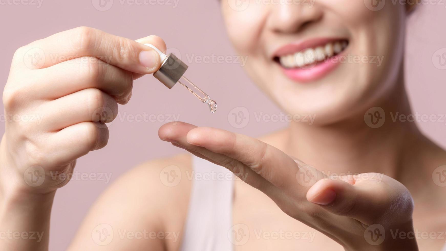 magnifique Jeune asiatique femme appliquant sérum faciale pétrole sur Naturel mack en haut visage peau. portrait santé bien-être nettoyer soin de la peau femelle attrayant la personne avec traitement compte-gouttes. beauté, cosmétologie concept photo