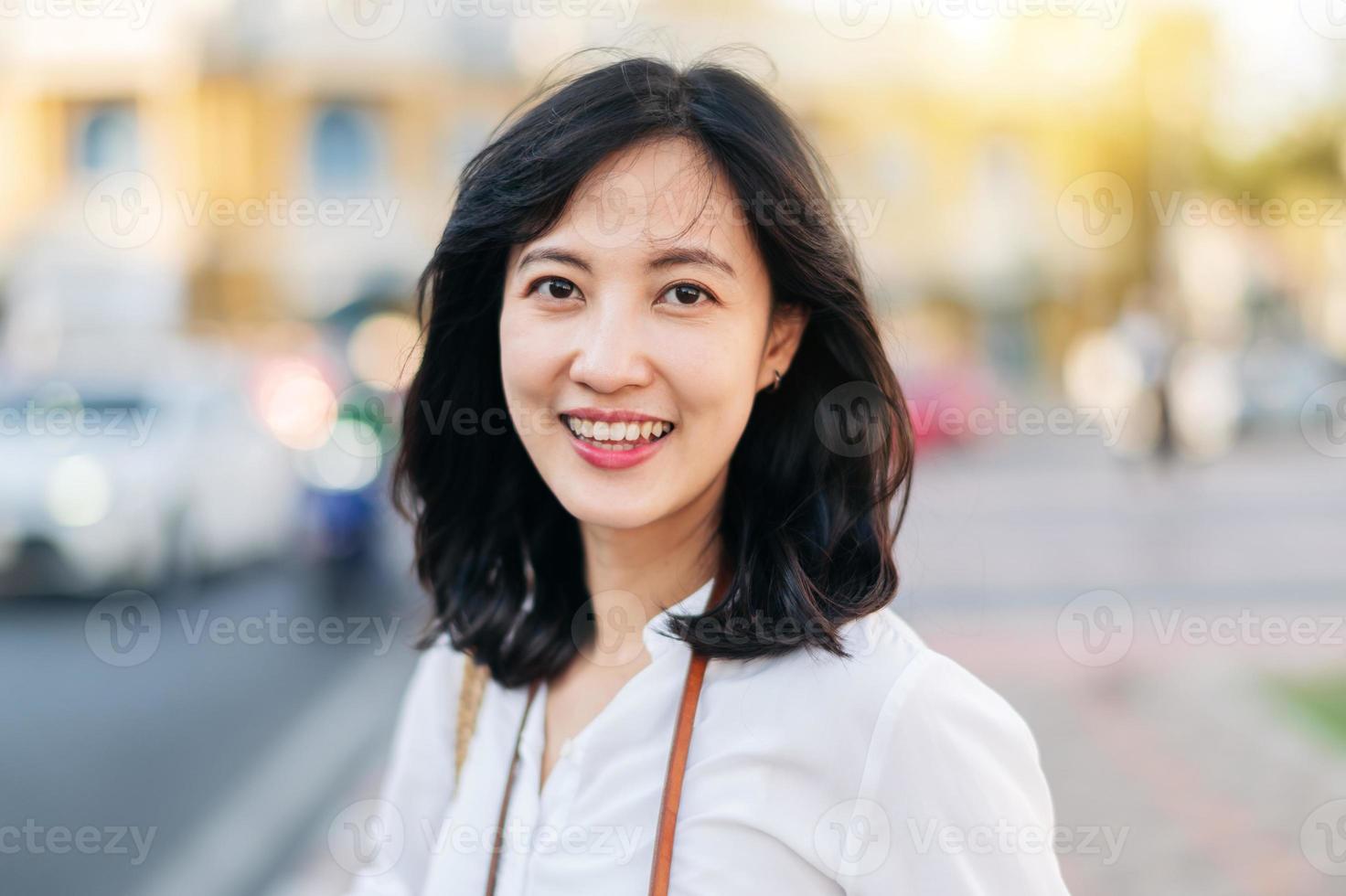 portrait magnifique asiatique femme voyageur souriant et à la recherche à caméra tandis que explorer rue sur été vacances dans Bangkok, Thaïlande photo