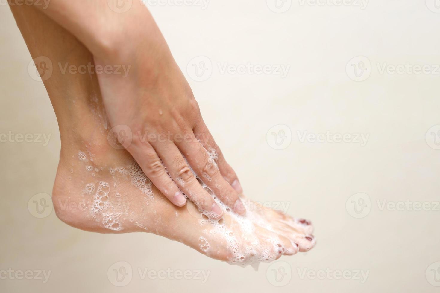 femme en utilisant liquide savon à nettoyer pieds à prévenir germes photo