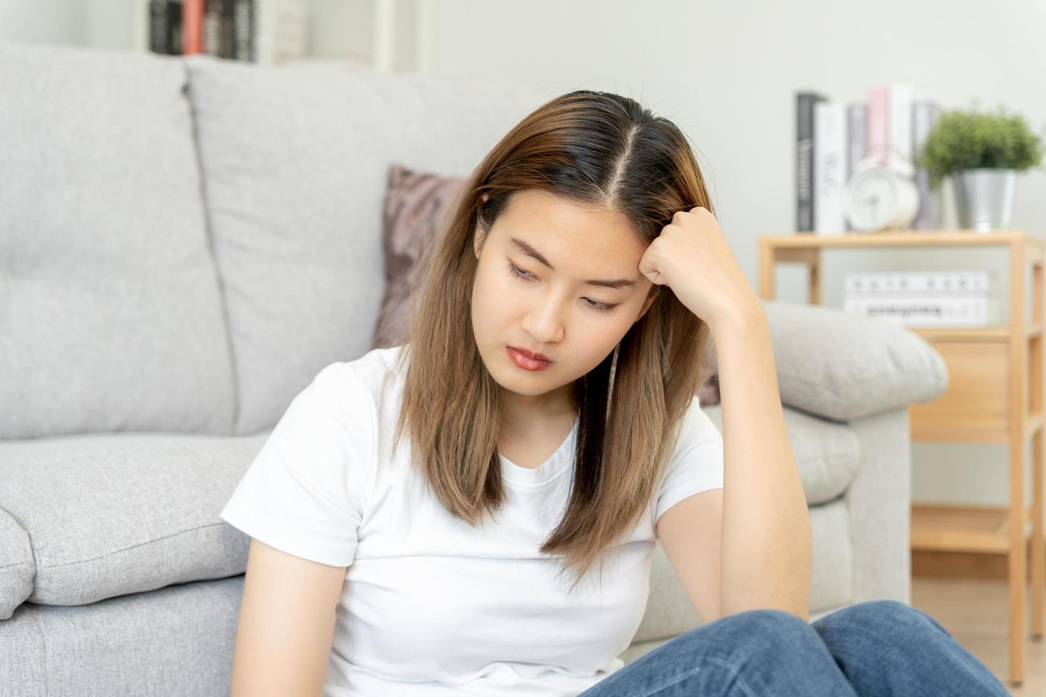 malheureuse femme asiatique fille déçue, triste à cause d'un problème à la maison seule, se sentir seule, stressée, souffrant d'une mauvaise relation, rompre, divorcer, femme confuse, dépression santé mentale, solitude photo