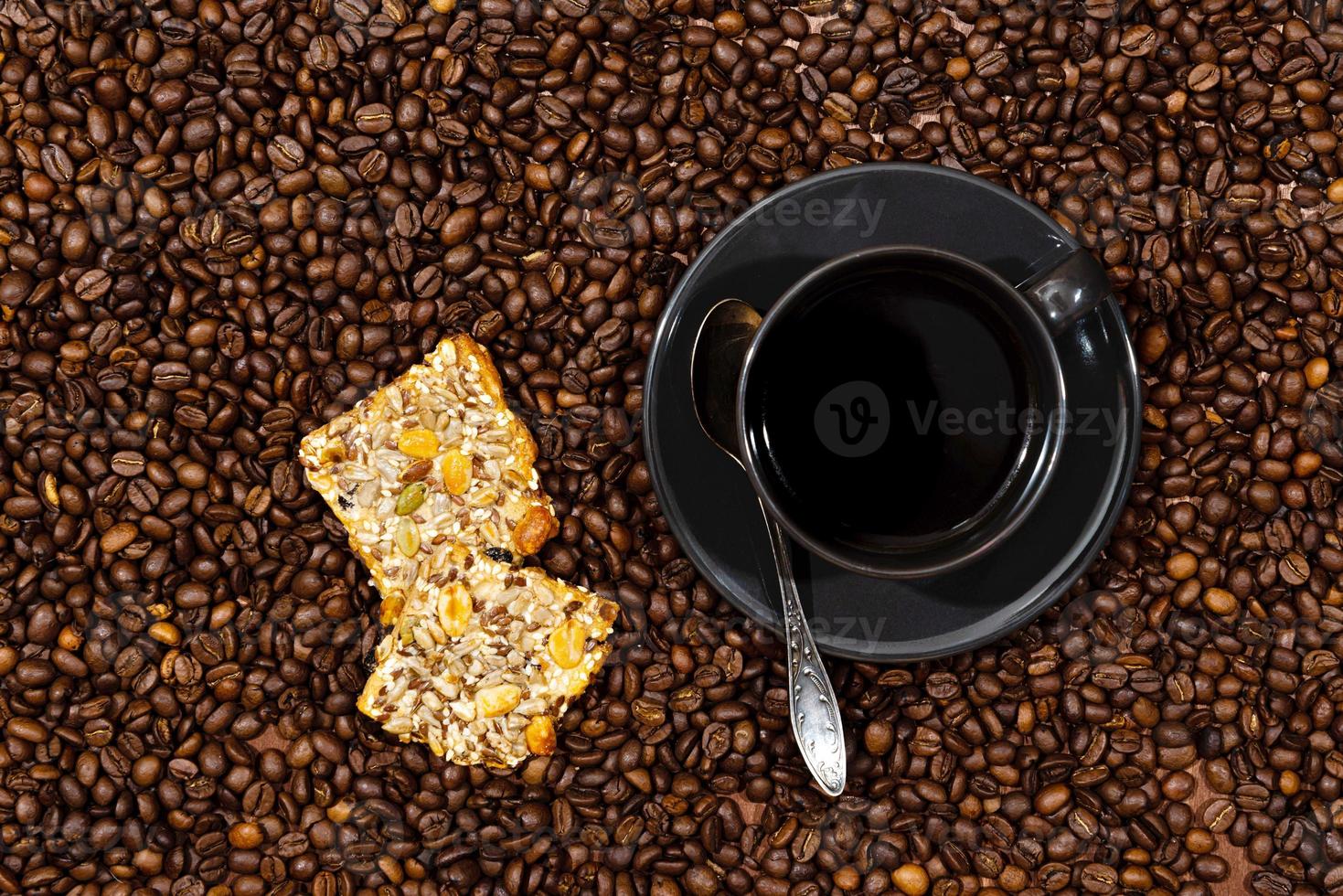 Vue de dessus de la tasse de café noir et des cookies sur le fond de grains de café photo