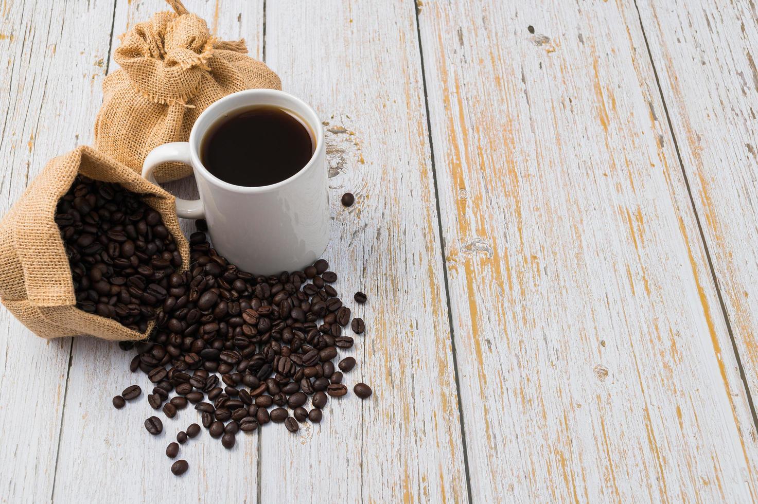 une tasse de café et des grains de café sur une table en bois photo