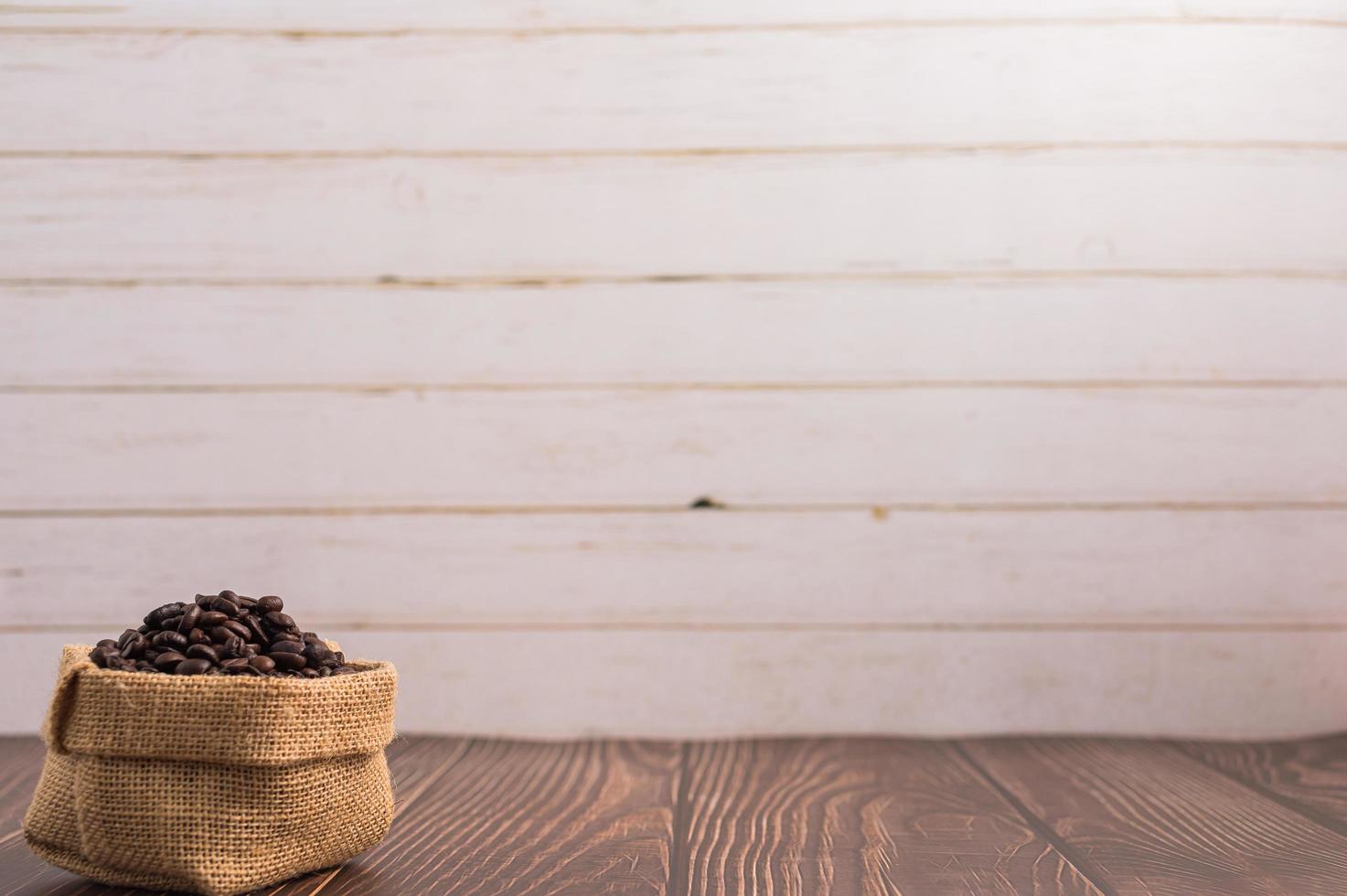 Sacs de grains de café sur une table en bois photo