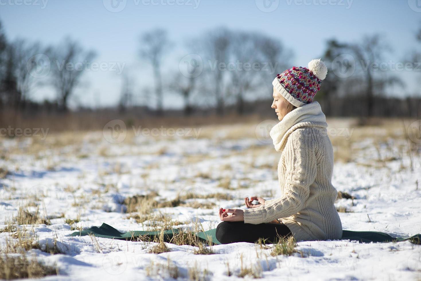 Une jeune femme athlétique effectue des exercices de yoga et de méditation à l'extérieur photo