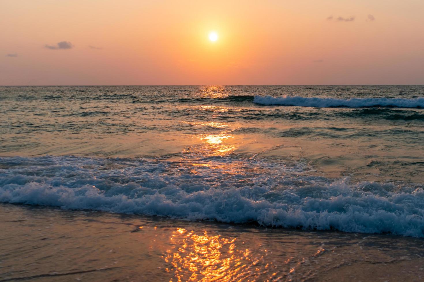 vagues de la mer de l'océan coloré pendant un lever ou coucher de soleil avec le soleil en arrière-plan photo