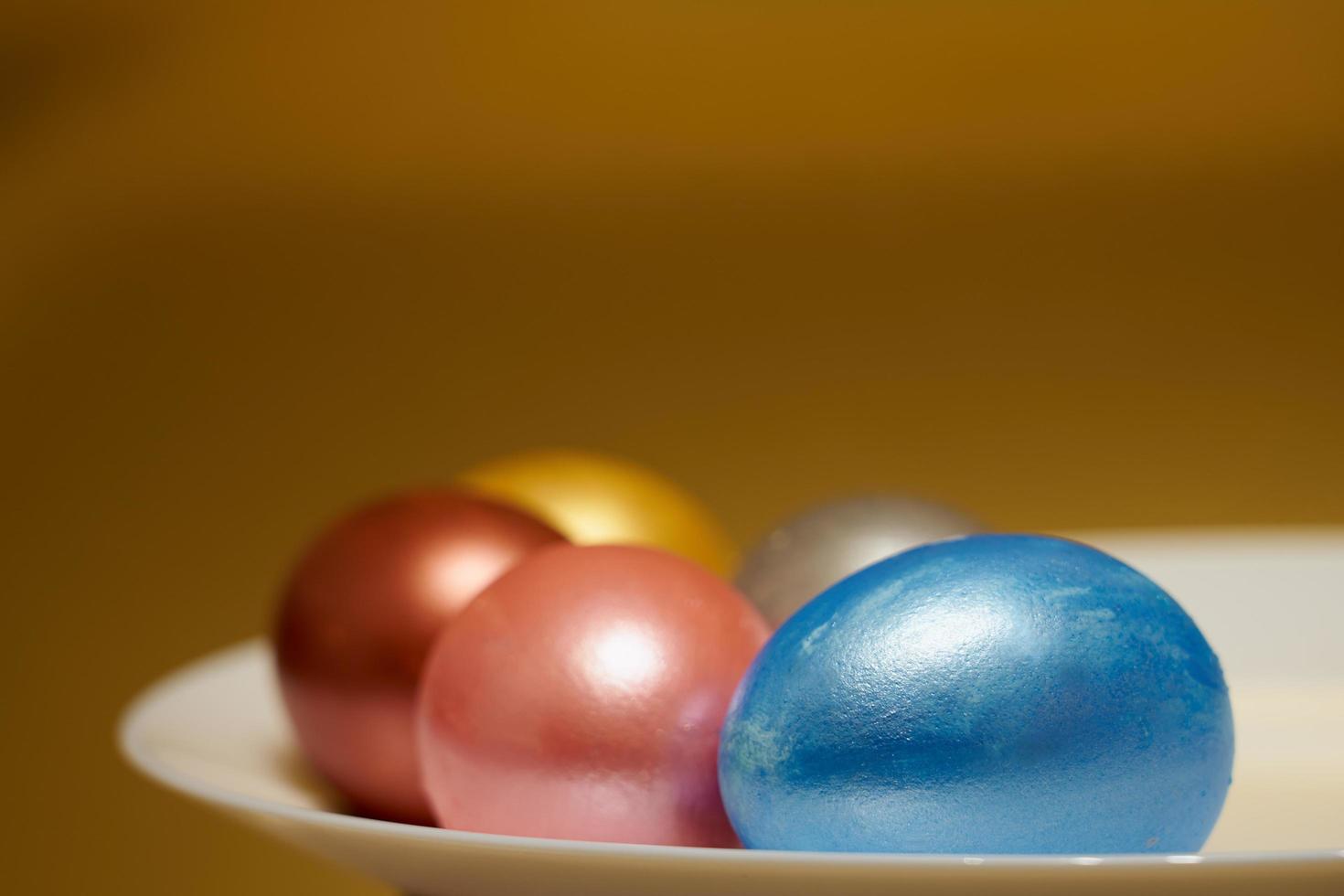 Oeufs de Pâques de couleur nacrée dans une boîte à œufs sur fond doré photo