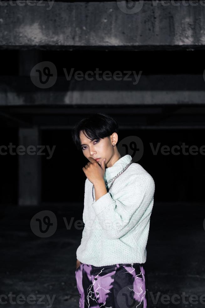 un asiatique homme posant dans une blanc chandail et une chaîne Collier autour le sien cou photo