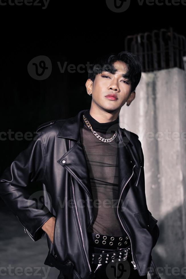 un asiatique homme dans une noir cuir veste posant comme une moto gang photo