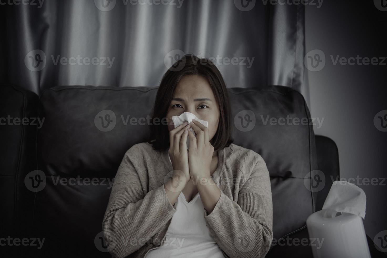 asiatique malade femme asseoir sur le canapé rester à maison, la femme se sentait mauvais, voulait à mensonge vers le bas et repose-toi, prends médicament photo