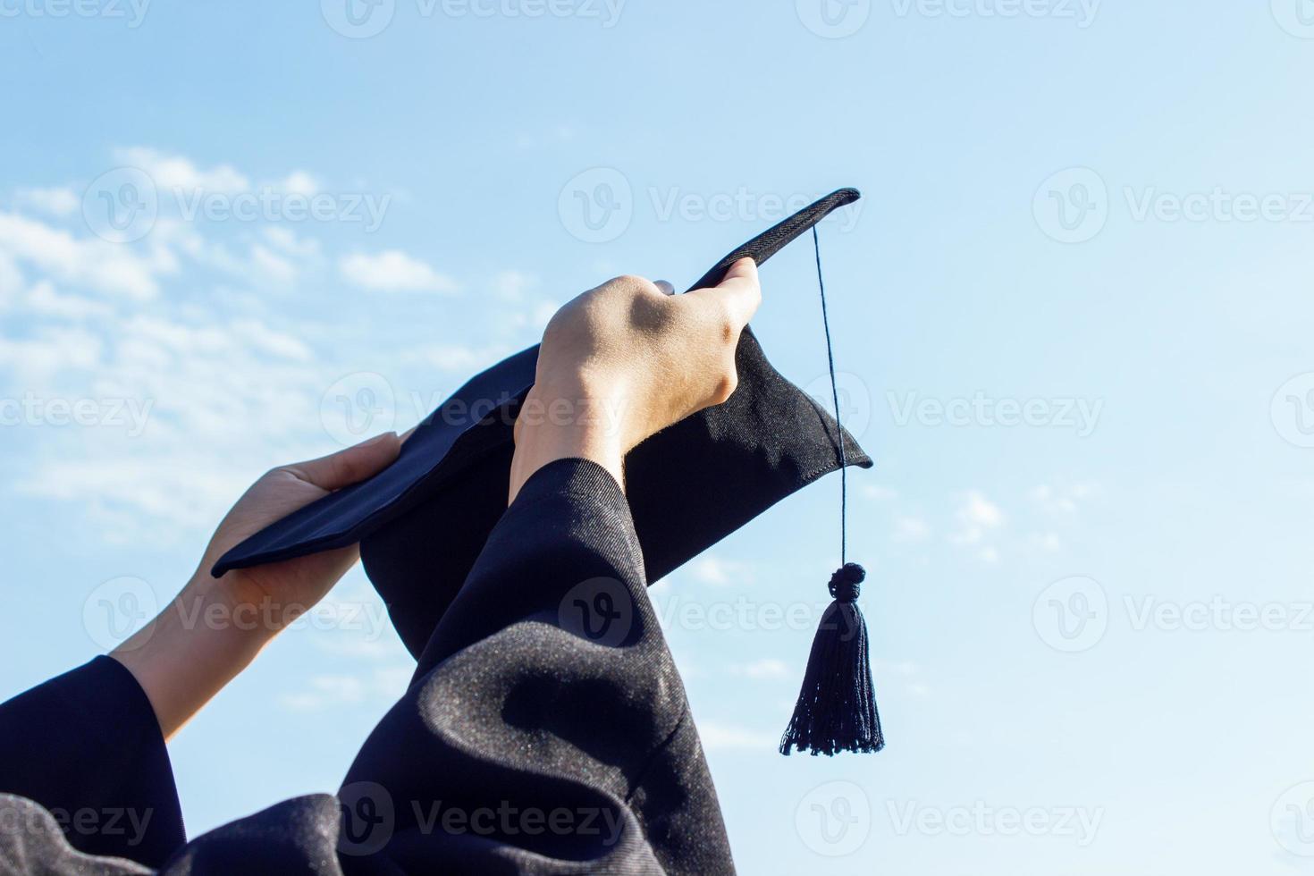 diplômé célébrer avec casquette dans sa main, sentiment donc fier et bonheur dans commencement journée photo