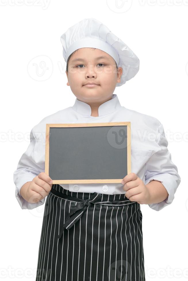 garçon chef dans uniforme cuisinier en portant tableau noir photo