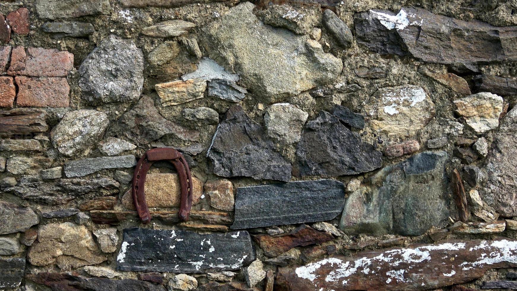vieux le fer fortune symbole fer à cheval sur pierre mur photo