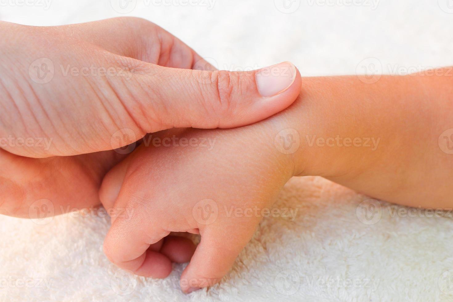 masseur Faire massage les doigts peu bébé. photo