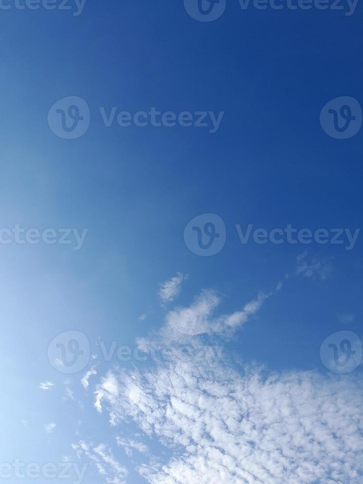 beaux nuages blancs sur fond de ciel bleu profond. de grands nuages doux et moelleux couvrent tout le ciel bleu. photo