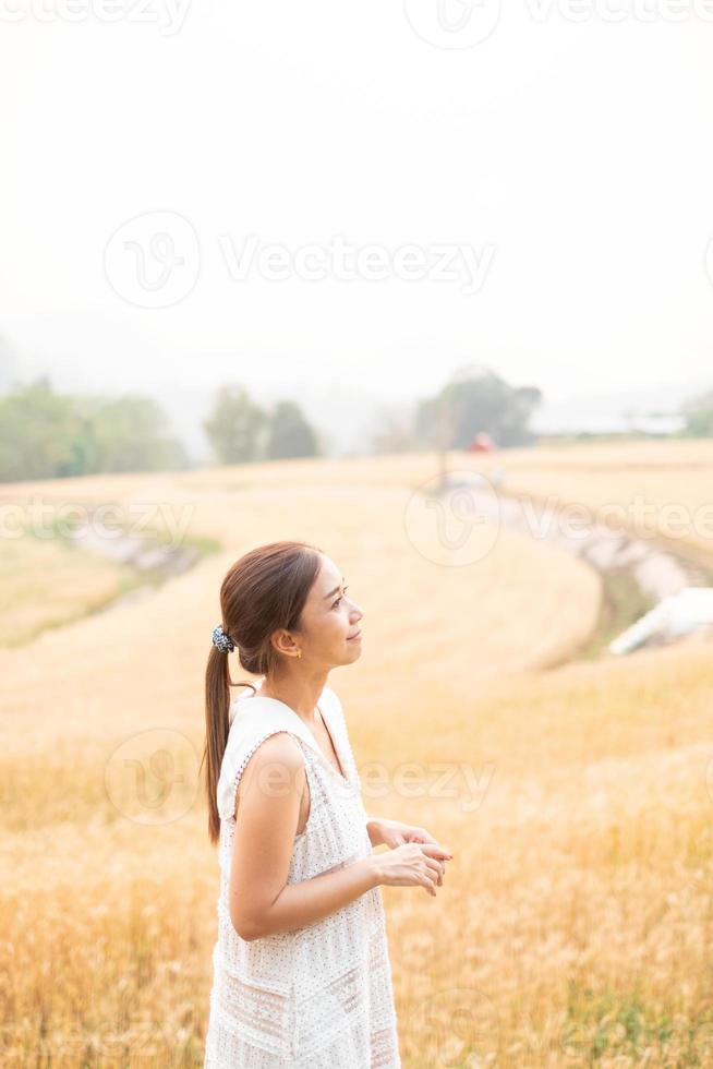 Jeune asiatique femmes dans blanc Robes dans le orge riz champ photo