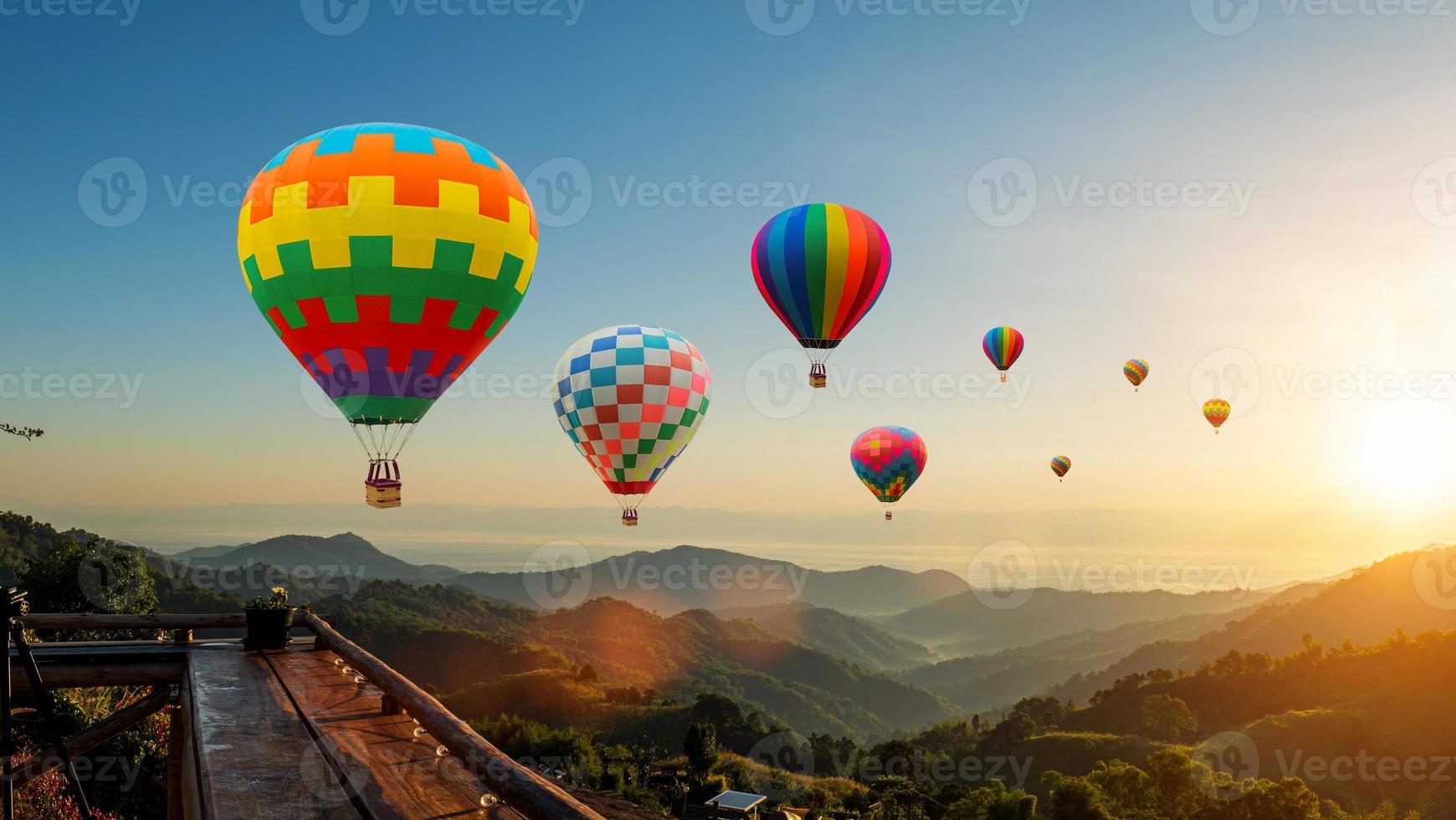 coloré chaud air des ballons en volant au dessus Montagne à lever du soleil ciel Contexte. Voyage Naturel Contexte. photo