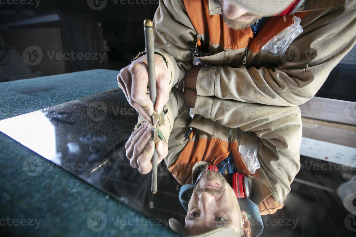 une ouvrier coupes verre avec une verre coupeur. meubles fabrication. photo