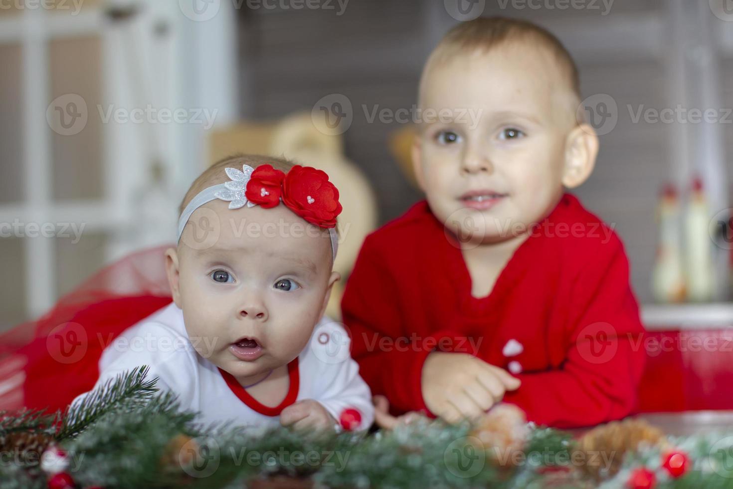 une peu nouveau née fille et sa frère dans une Nouveau années emplacement. photo