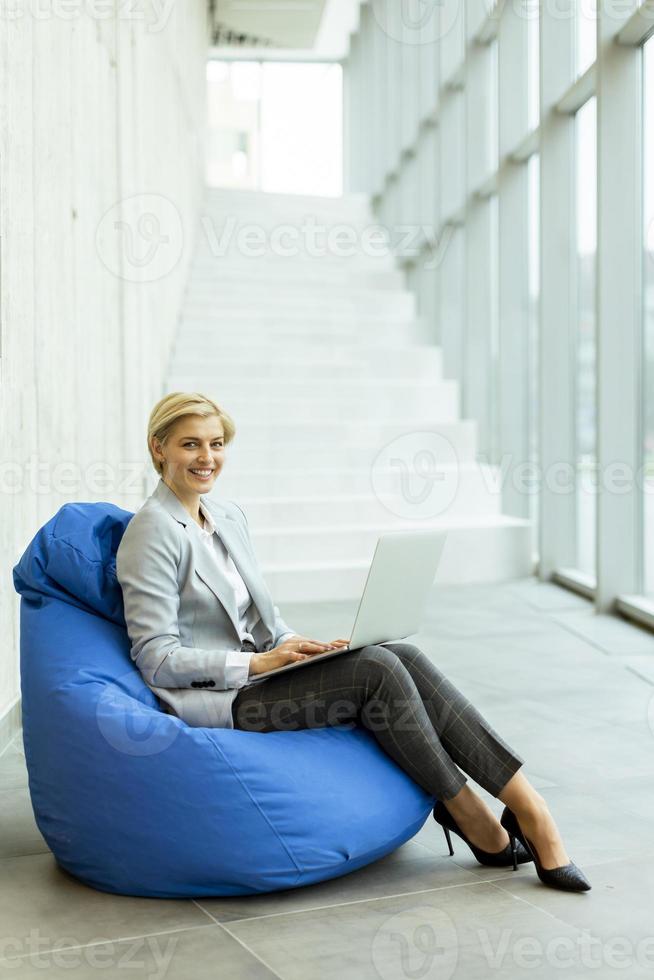 femme d'affaires utilisant un ordinateur portable sur un sac paresseux dans le bureau moderne photo