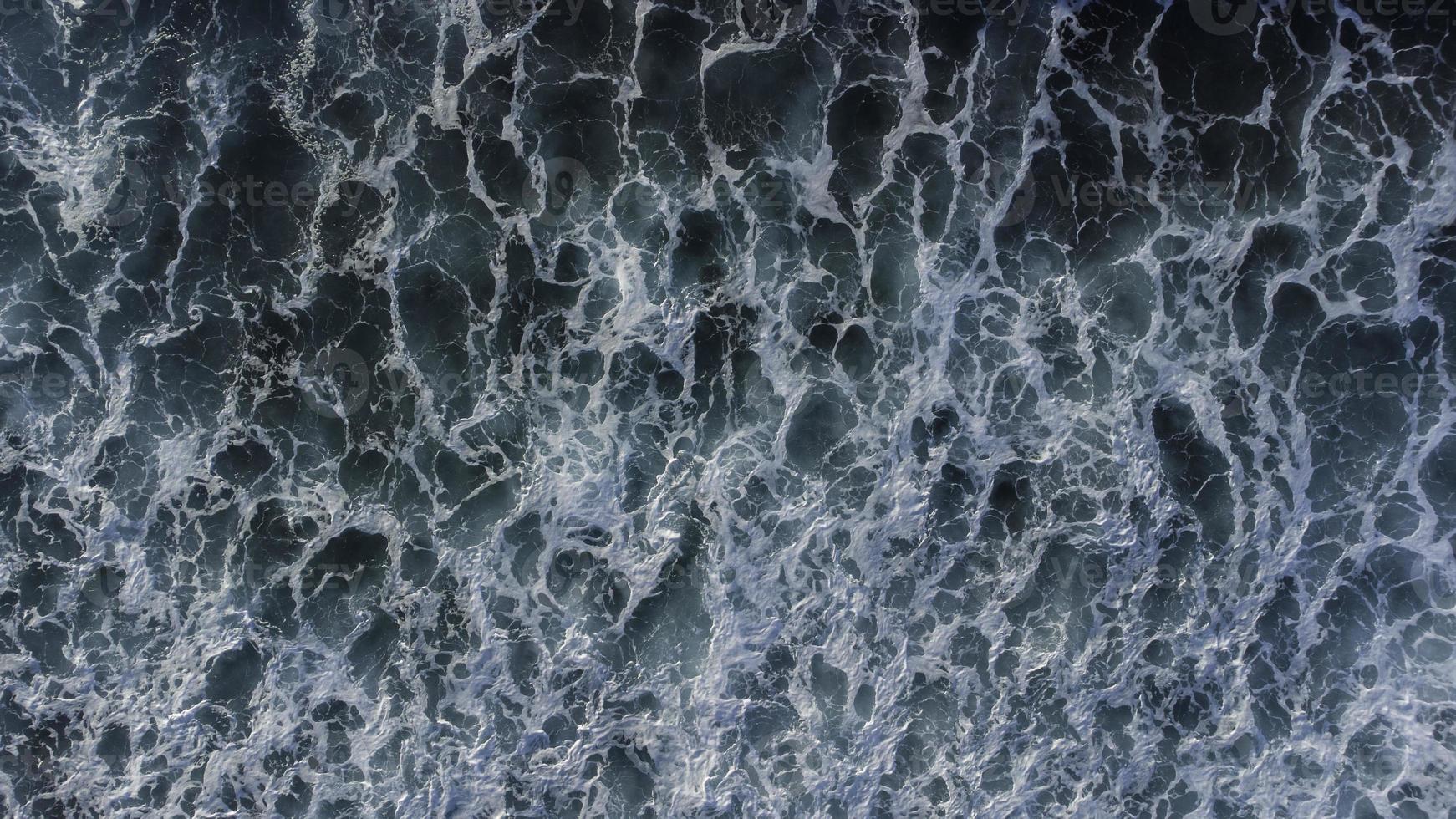 un inspirante vue de vagues s'écraser le long de le plage, capturé de un aérien perspective. photo