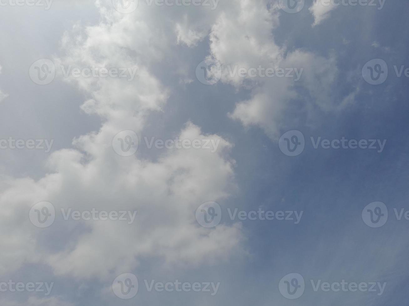 nuages blancs dans le ciel bleu. beau fond bleu clair. peu nuageux, beau temps. nuages bouclés par une journée ensoleillée. photo