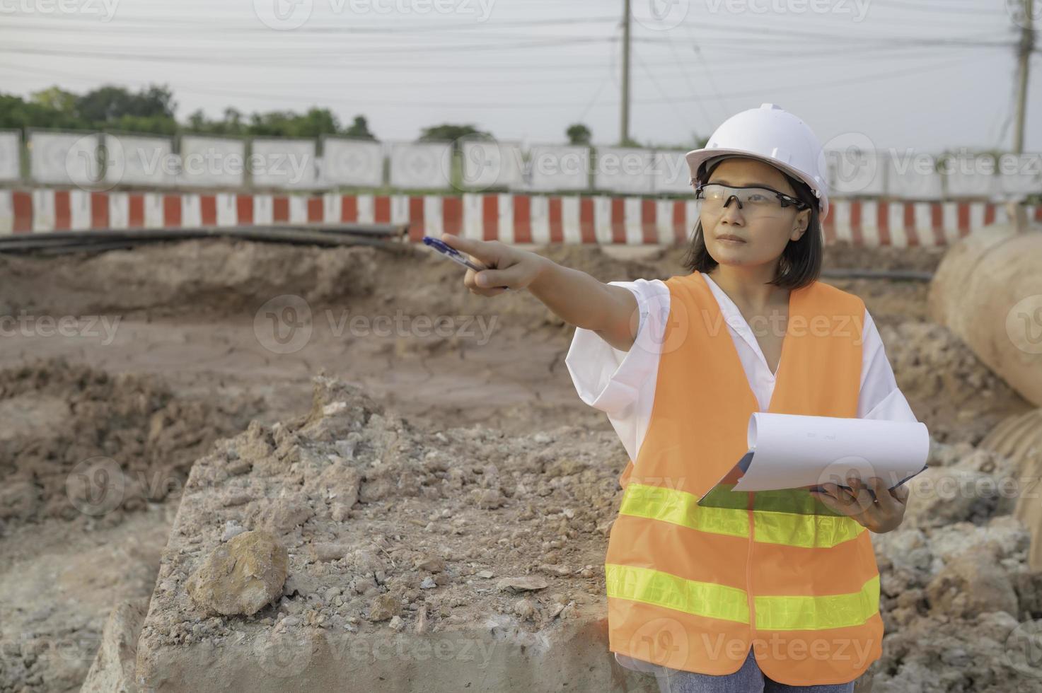 civil ingénieurs travail à une construction chantier, le entreprise directeur supervise le route construction. photo