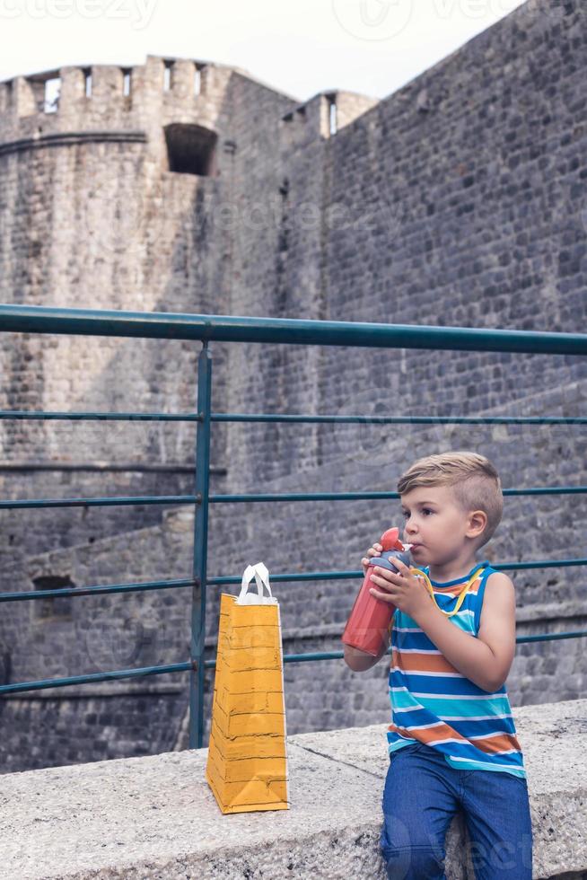 petit garçon, boire, eau, dans, ville photo