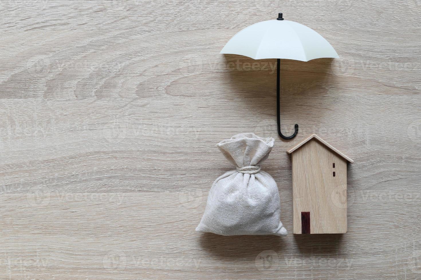 maison modèle et parapluie sur fond de bois photo