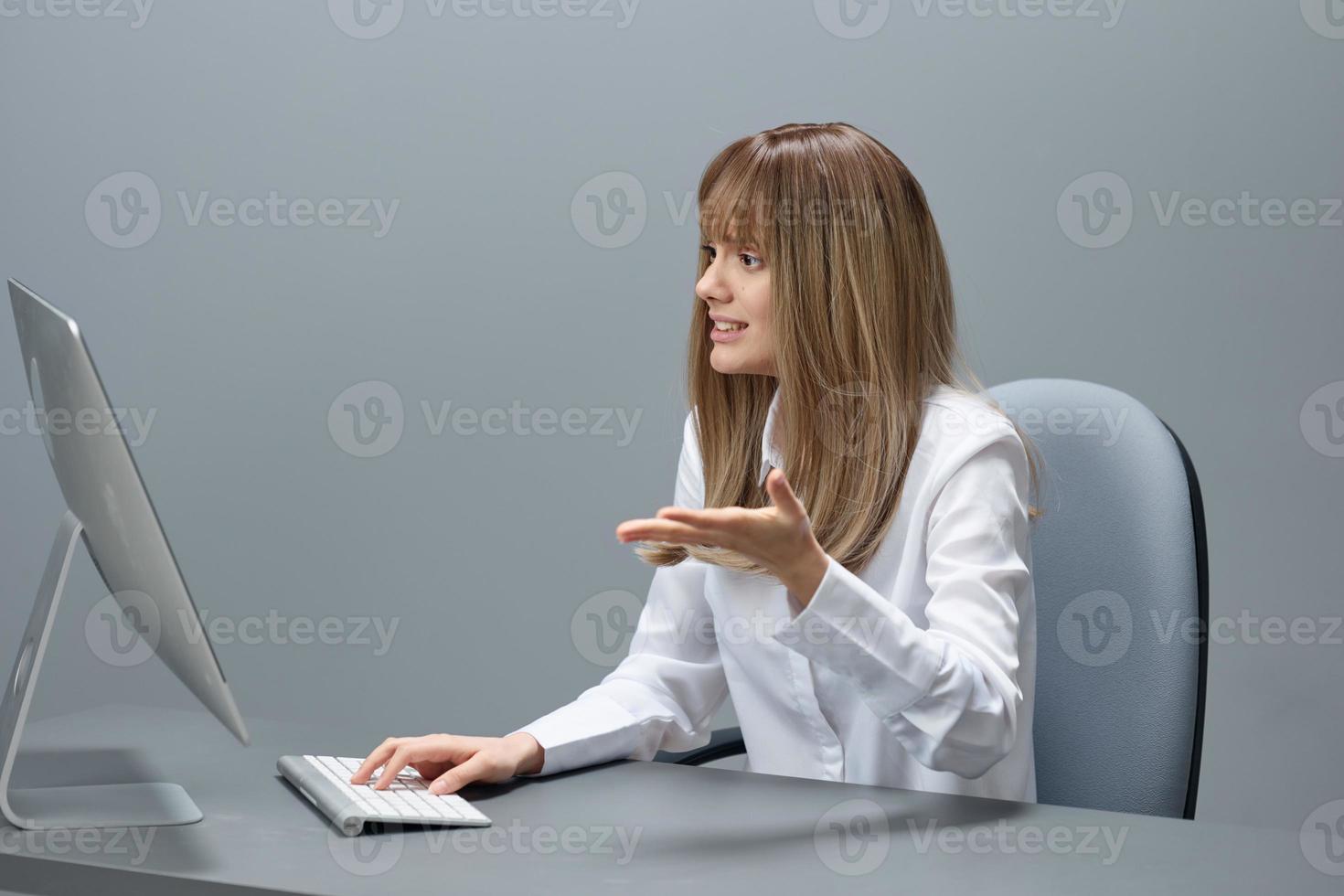 nerveux jolie blond femme d'affaires ouvrier pigiste avoir opération crash en utilisant bureau ordinateur séance à lieu de travail dans gris moderne bureau. éloigné emploi, La technologie et carrière profession concept photo