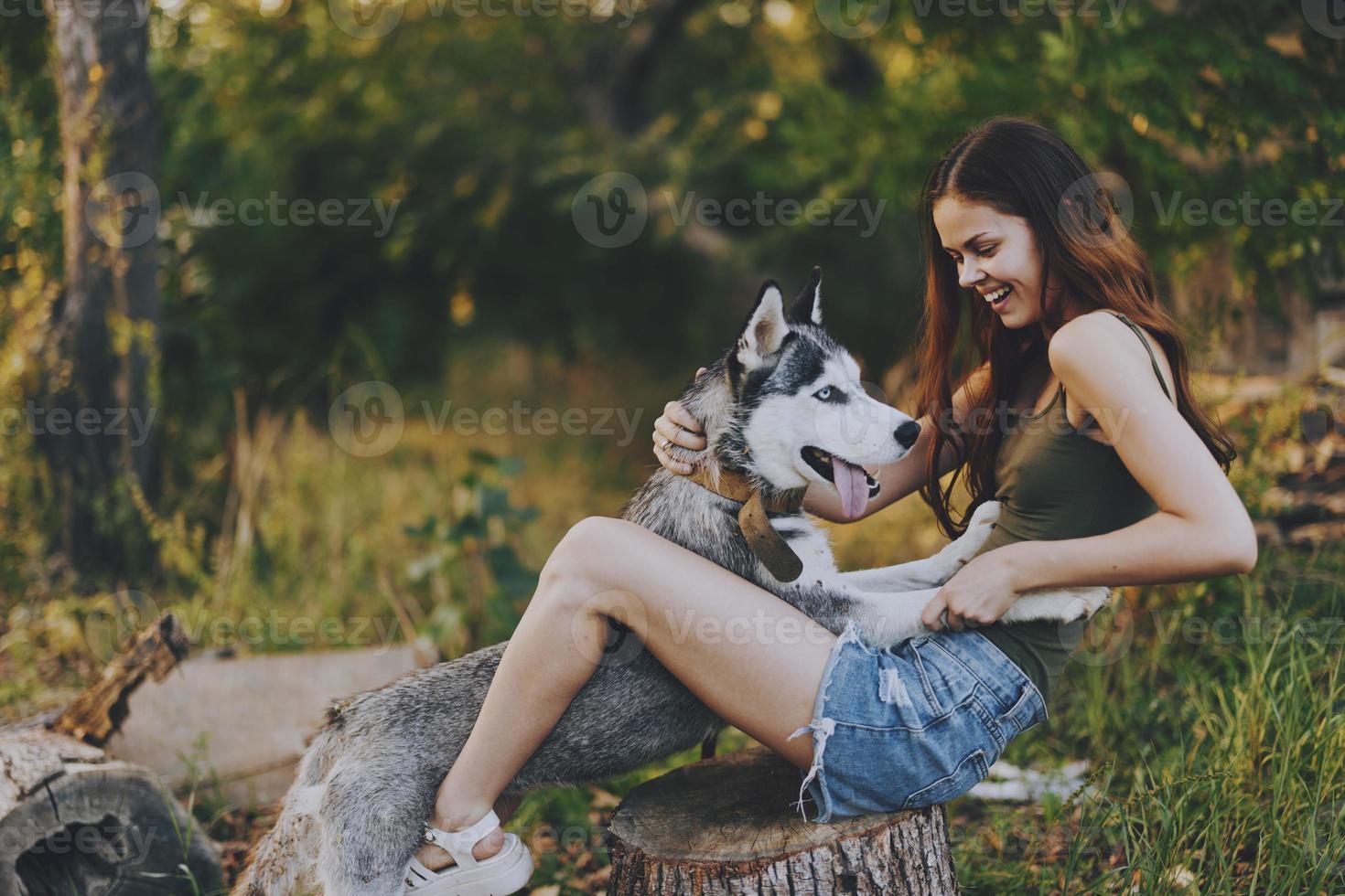 femme et sa rauque chien Heureusement en jouant en plein air dans le parc parmi le des arbres sourire avec les dents dans le l'automne marcher avec sa animal de compagnie photo