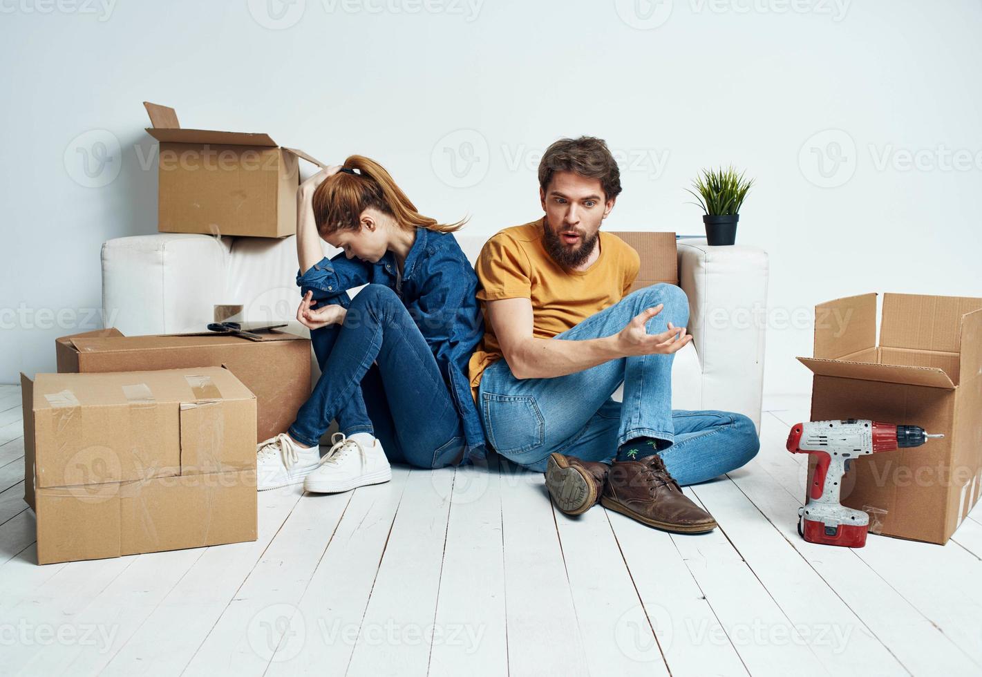 Hommes et femmes dans une Nouveau appartement en mouvement réparation travail des boites des trucs photo