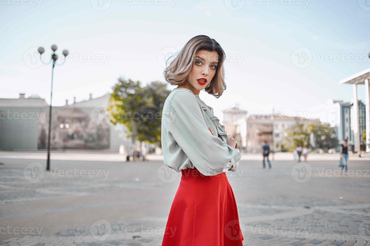 blond dans rouge jupe en plein air en marchant en plein air posant photo