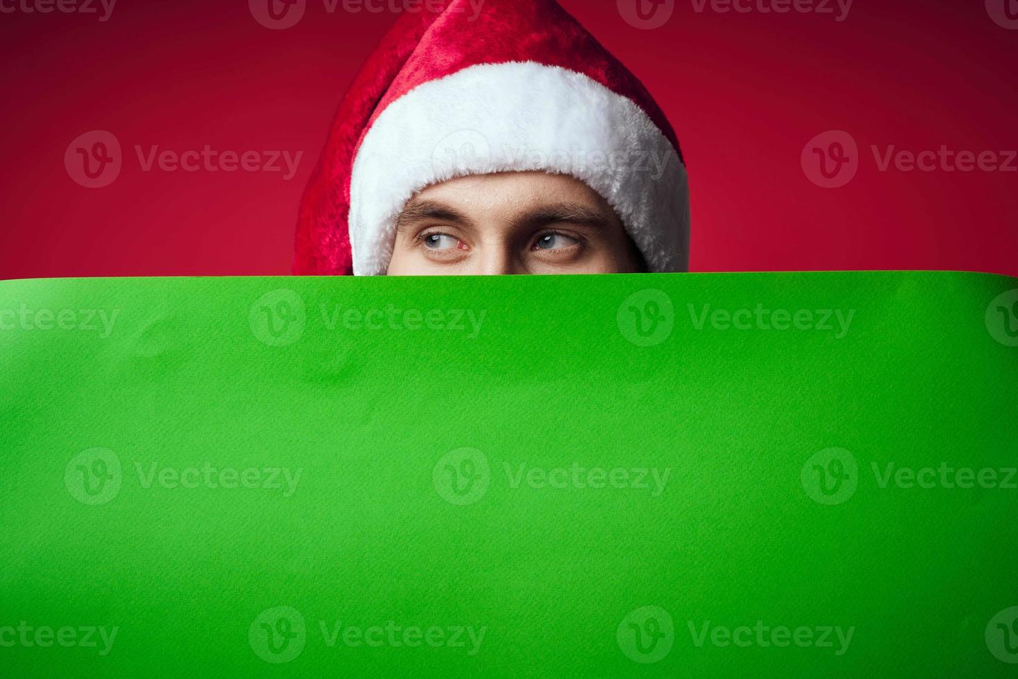 Beau homme dans une Père Noël chapeau en portant une bannière vacances studio posant photo