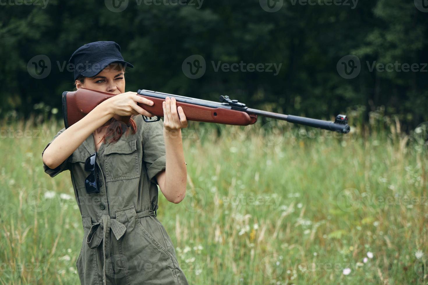 femme femme à la recherche dans le vue de une pistolet chasse mode de vie noir casquette photo