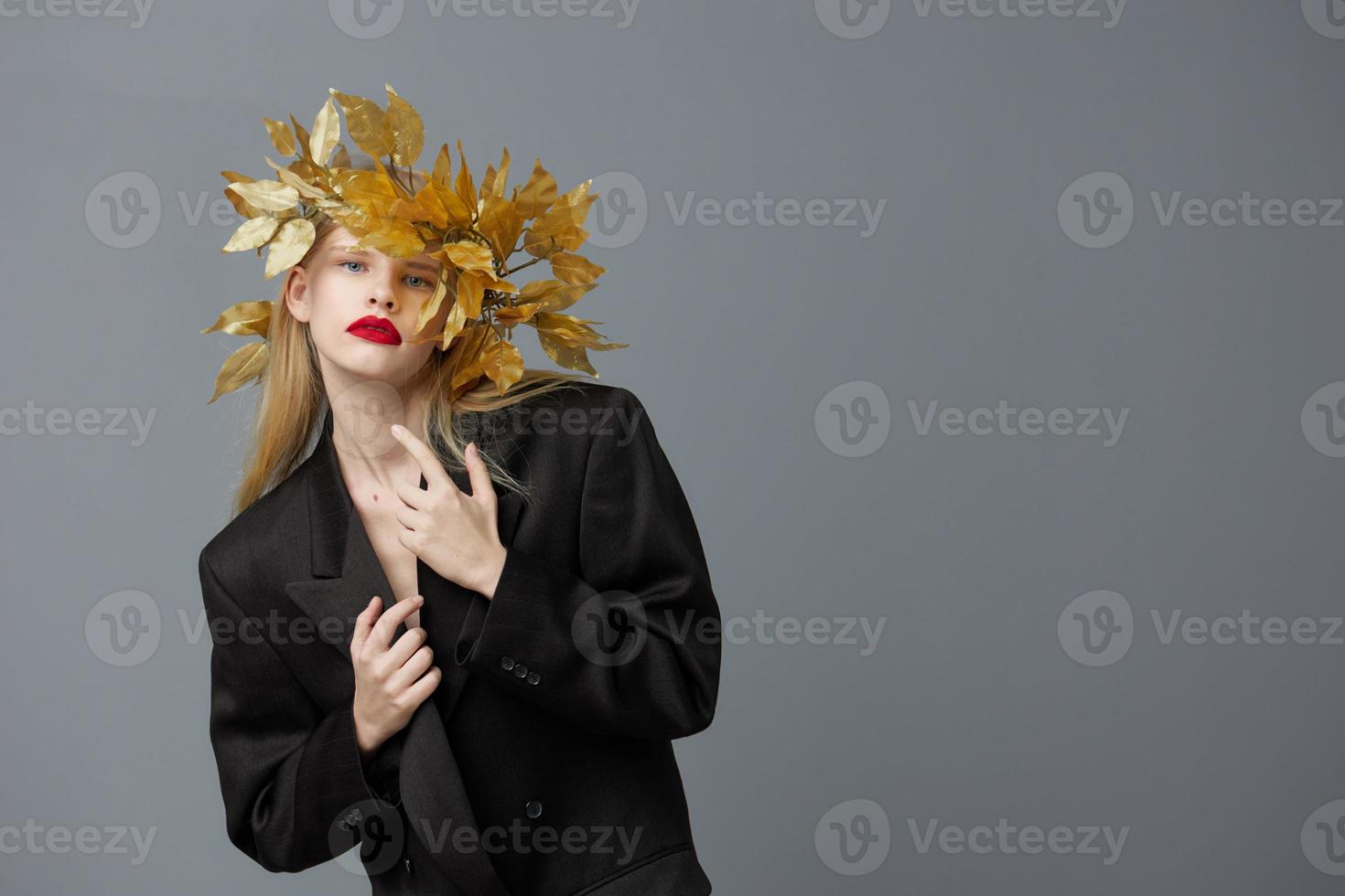 portrait de une femme d'or feuilles sur le tête dans noir veste mode de vie posant photo