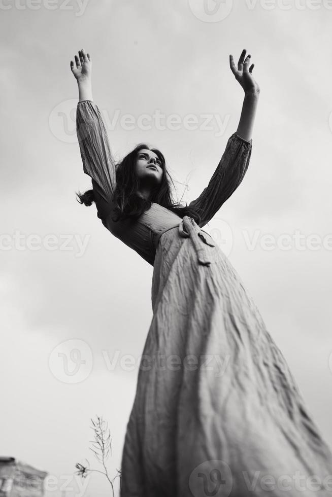 jolie femme dans robe faire des gestes avec mains posant noir et blanc photo