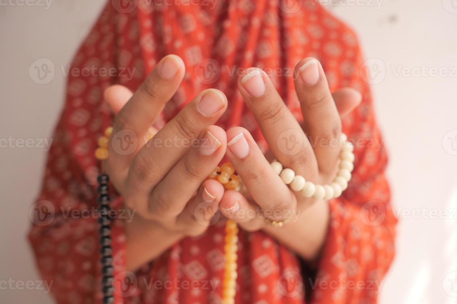gros plan des mains priant avec des perles photo