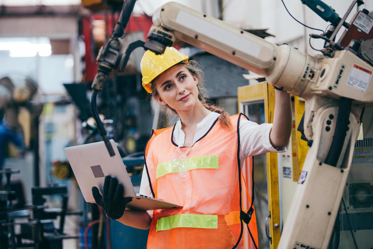 Femme inspectant les machines tout en tenant un ordinateur portable photo