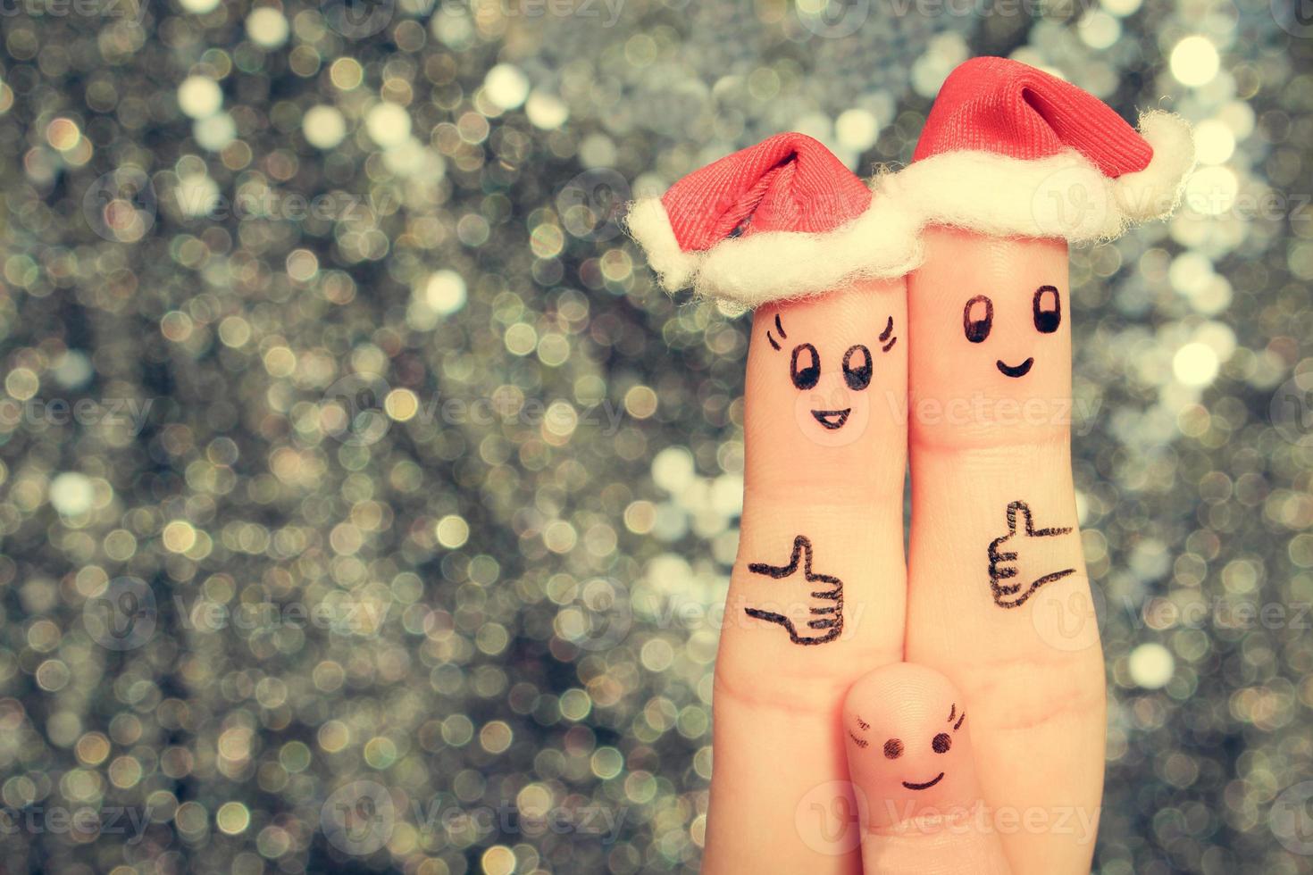 doigt art de grand famille fête Noël. concept de groupe de gens en riant dans Nouveau année Chapeaux. content couple montrant les pouces en haut. tonique image. photo
