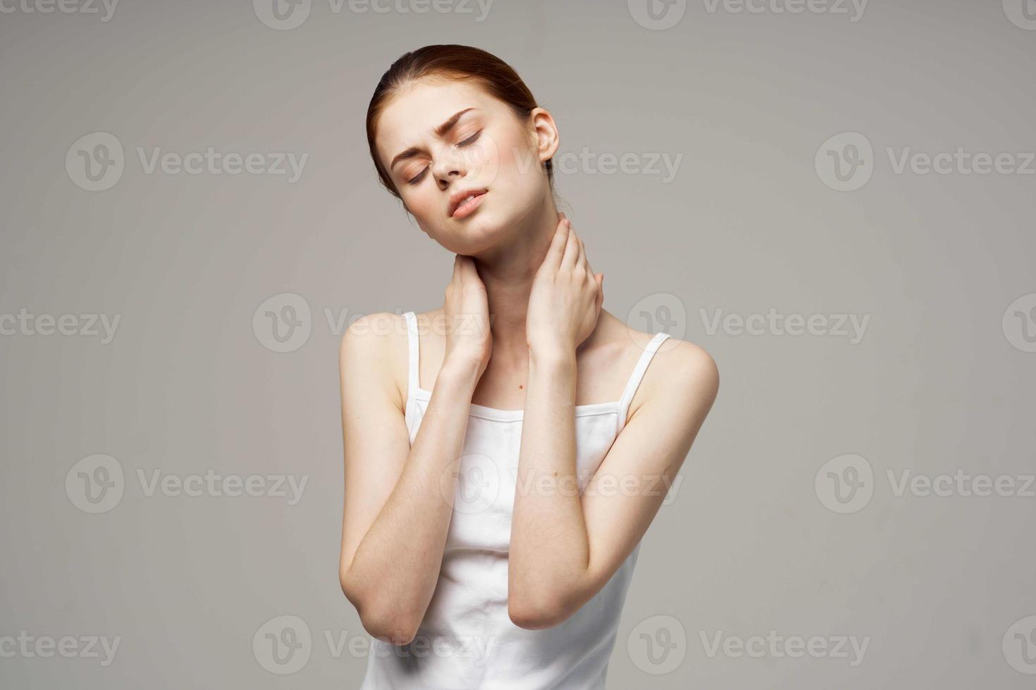 femme dans blanc T-shirt en portant sur à le cou santé problèmes mixte lumière Contexte photo