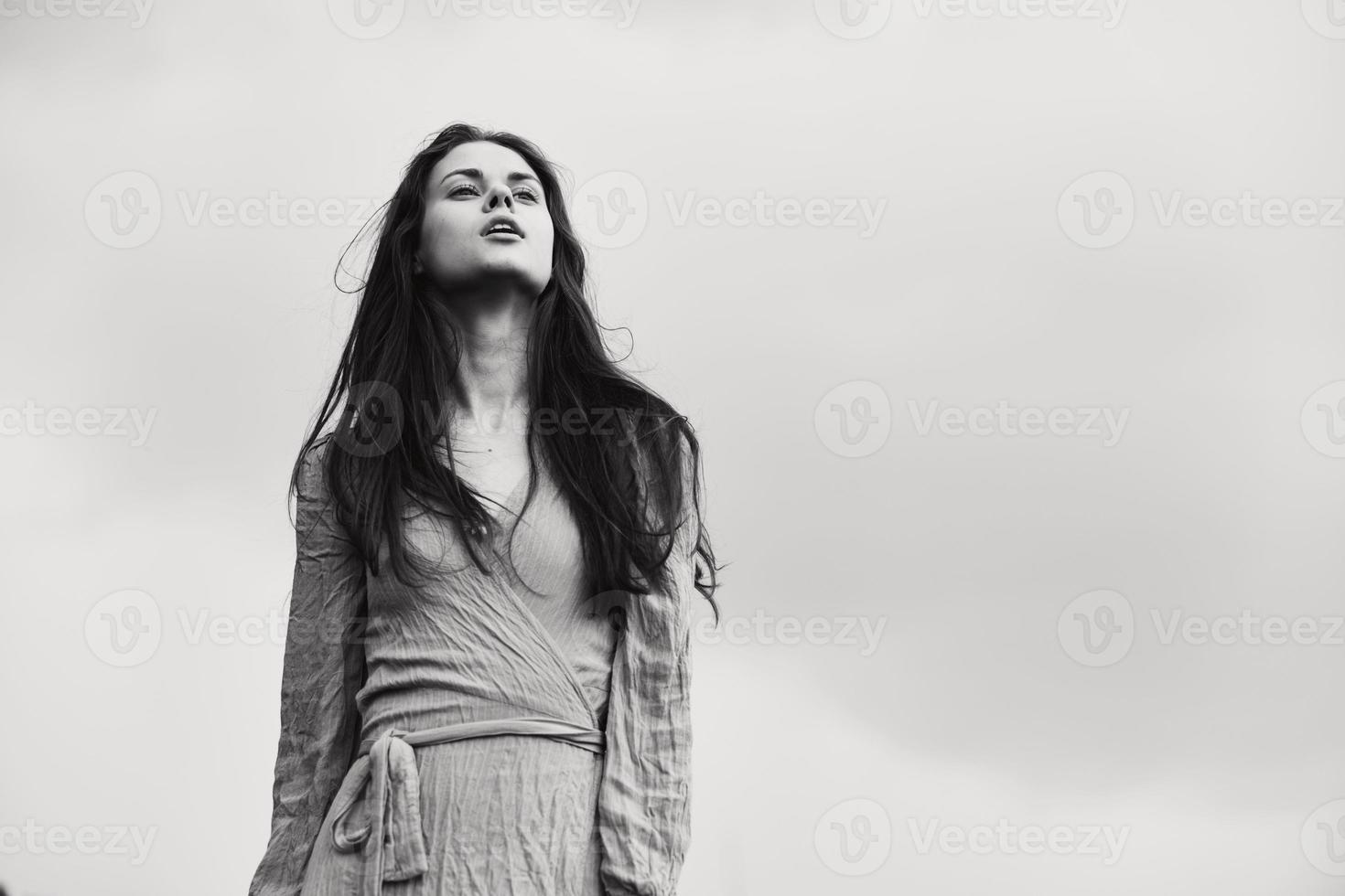 portrait de une magnifique femme dans robe faire des gestes avec mains posant noir et blanc photo