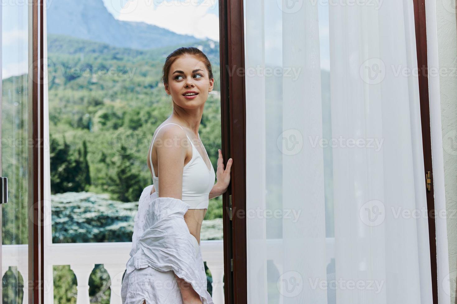 portrait de Jeune magnifique femme dans lingerie sur le balcon magnifique vue de le fenêtre relaxation concept photo