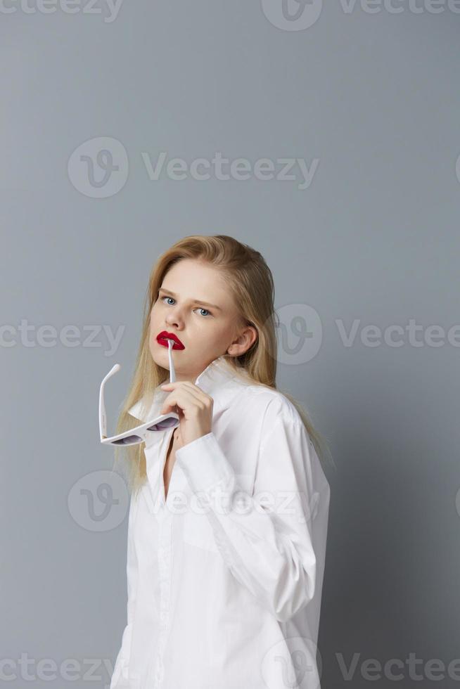 portrait de une femme rouge lèvres mode des lunettes isolé Contexte photo