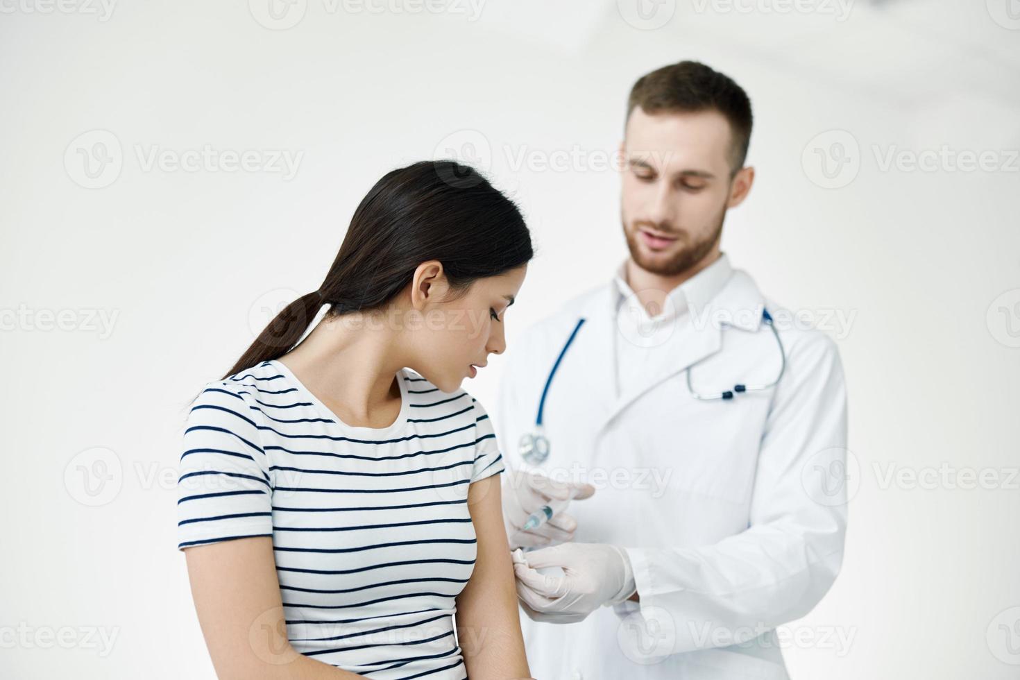 Masculin médecin donnant un injection à une patient dans une hôpital vaccination photo